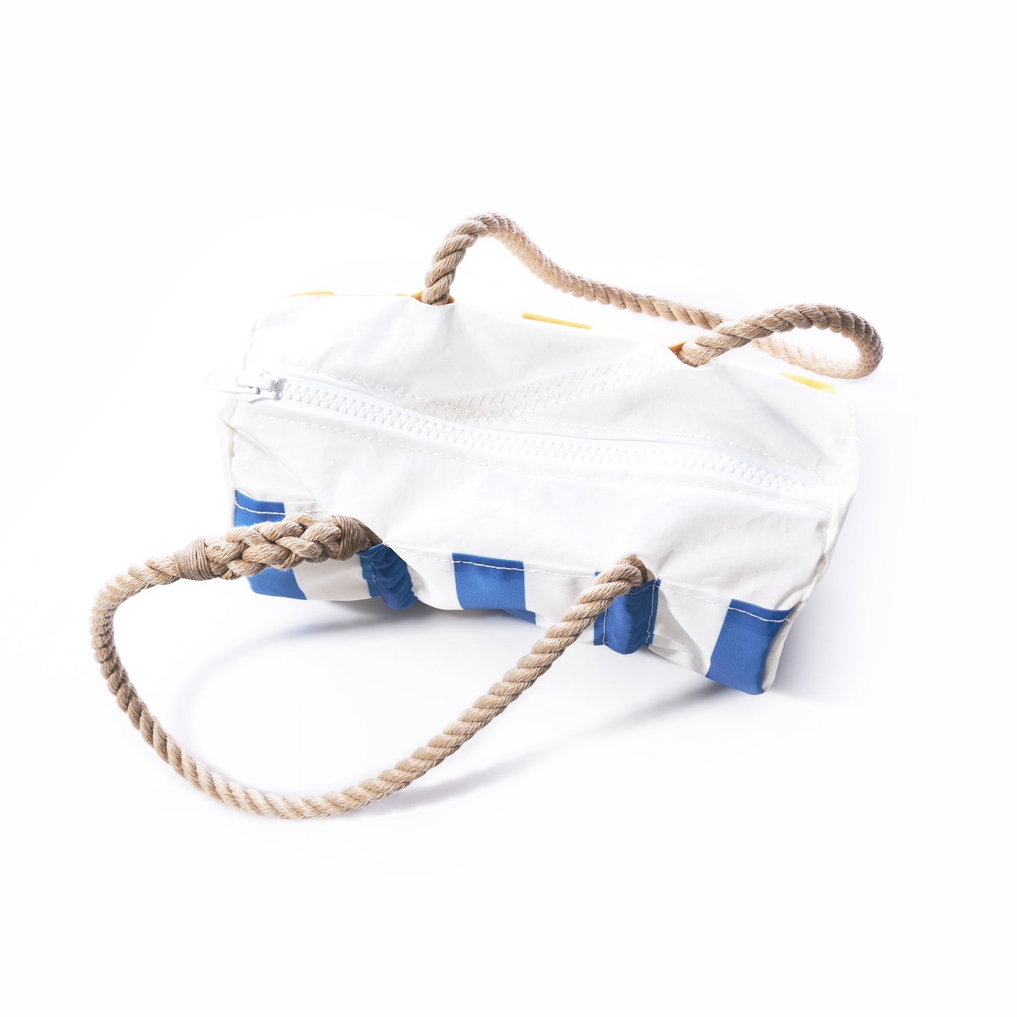 The Sun Sea Stripe Baguette Bag by Sea Bags is a white, rectangular recycled sailcloth bag featuring blue accents, a zipper closure, and two thick braided rope handles, shown on a white background. by Sea Bags