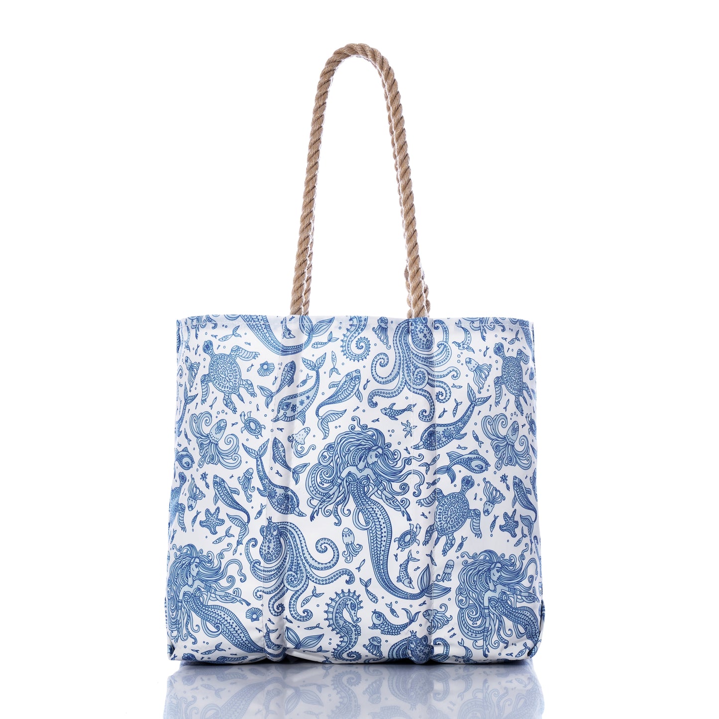 Paisley Mermaid Medium Tote by Sea Bags, featuring blue and white sea life patterns and tan rope handles, is displayed upright on a white background with a reflection below. by Sea Bags