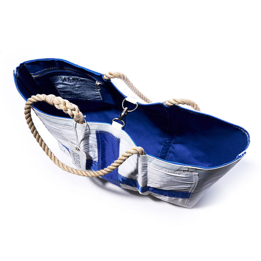 The Sea Bags Xray Signal Flag Large Tote is a blue and white handcrafted bag inspired by vintage sail cloth, featuring rope handles, a metal clasp, an inner pocket, and a blue fabric lining. by Sea Bags