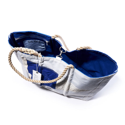 Sea Bags 2nd Repeat Signal Flag Large Tote, handcrafted from vintage sail cloth in blue and white with sturdy rope handles, shown open to reveal the interior lining, label, and attached tag, photographed on a white background. by Sea Bags
