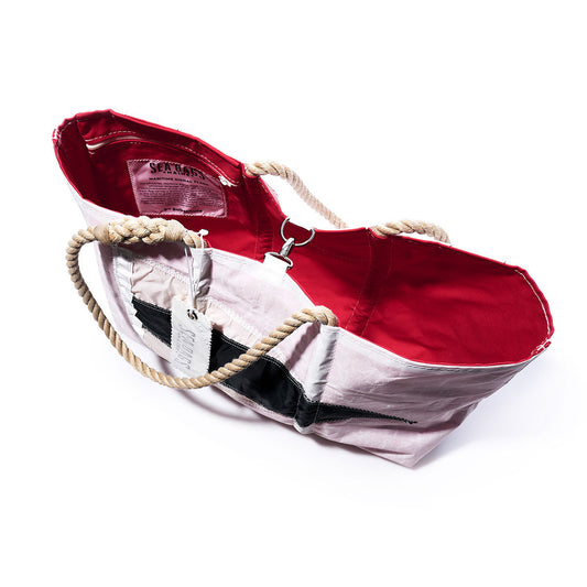 The Sea Bags 3rd Repeat Signal Flag Large Tote—crafted from recycled sail cloth and inspired by vintage signal flags—features rope handles, a bold black diagonal stripe on the exterior, and a vibrant red interior; it is photographed on a white background. by Sea Bags