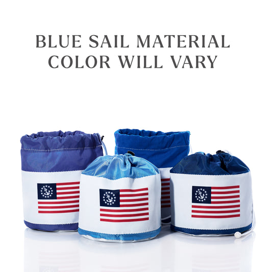 Set of four Sea Bags U.S. Yacht Ensign Ditty Bags, crafted from blue recycled sail cloth and each adorned with an American flag patch, showcase timeless nautical style. The varying shades of blue emphasize their sustainable craftsmanship and unique character; text above reads “color will vary.” Displayed on a clean white background. by Sea Bags