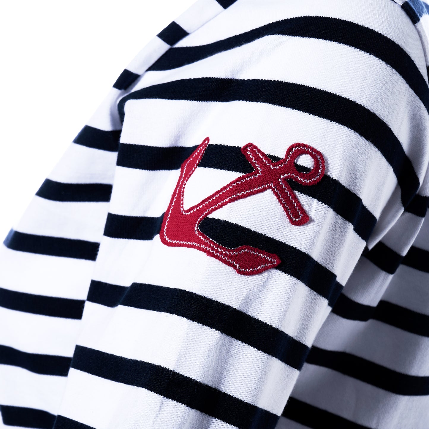 Detailed close-up of the Batela USA Inc 3/4 Sleeve Boatneck Top in navy Breton stripes, featuring a red embroidered anchor on the sleeve that highlights its timeless nautical style.