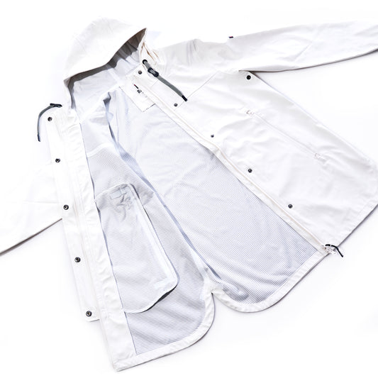 Harborside Waterproof Raincoat - White by Batela USA Inc laid flat, unzipped to reveal its inner mesh lining, side pockets, and snap button closures—a lightweight raincoat with a waterproof shell thats perfect for coastal weather. by Sea Bags