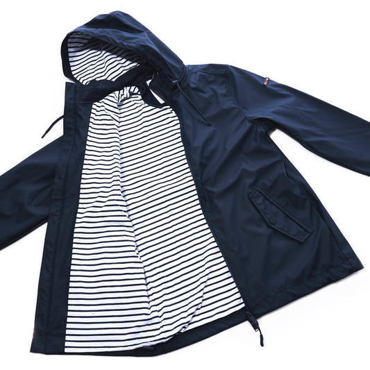 Batela USA Inc Waterproof Raincoat Button Pocket - Navy, a unisex navy blue raincoat featuring a hooded, waterproof shell, button closure, two side pockets, and a white and black striped inner lining, displayed open on a white background. by Sea Bags