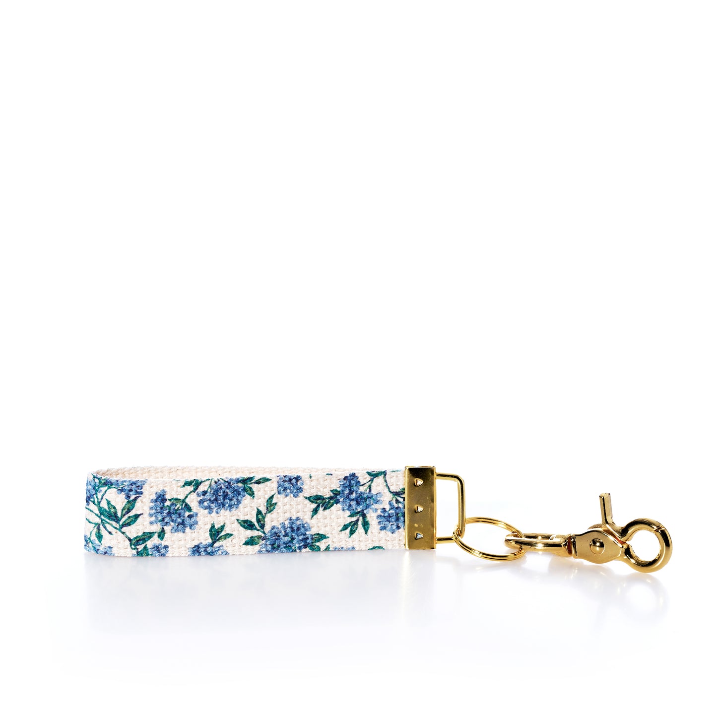 The Rustic Marlin Keychain - Blueberry by Rustic Marlin features a charming blue floral pattern and gold keyring, displayed on a white background—perfect as a stylish bag charm or unique blueberry keychain accessory. by Sea Bags