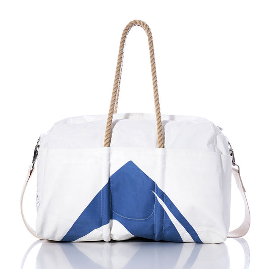 The Sea Bags Vintage Tartan 4300 Weekender features a classic white design with blue geometric accents, sturdy rope hemp handles, and a beige shoulder strap. Displayed on a reflective surface with a white background, this versatile getaway bag is perfect for your next adventure. by Sea Bags