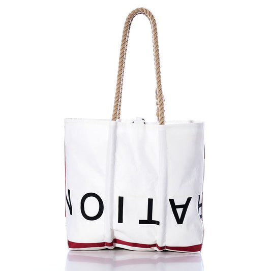 White tote bag with rope handles, showcasing large partial black text and red accents near the bottom, displayed against a plain white background. The Sea Bags Vintage ROY Medium Tote offers timeless style and durability, inspired by traditional handcrafted Maine bags and crafted from authentic recycled sailcloth for lasting quality. by Sea Bags