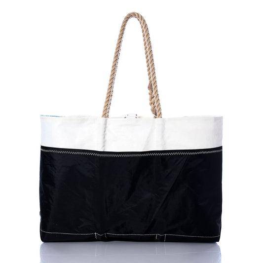 The Vintage Red and Black Ogunquit Beach Tote by Sea Bags is a spacious bag crafted from recycled sail cloth, featuring a white upper section, a bold red and black lower section, and finished with a thick twisted rope handle—making it the perfect beach companion. Photographed on a white background. by Sea Bags