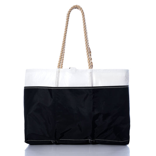 The Sea Bags Vintage Red C Ogunquit Beach Tote is a large beach tote bag made from recycled sail cloth, showcasing a white top, black bottom, and a sturdy twisted rope handle with vintage red stitching accents, displayed on a white background. by Sea Bags