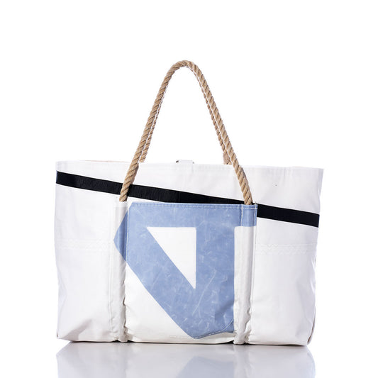 The Sea Bags Vintage Blue U Wharf Tote features a white body with a bold black diagonal stripe, a striking blue geometric patch, and sturdy rope handles. Hand-crafted and inspired by classic Portland, Maine style, this tote bag is perfect for everyday use and is displayed here on a clean white background. by Sea Bags