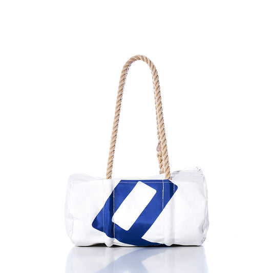 Sea Bags Vintage 420 Baguette Bag—a white cylindrical sail insignia bag adorned with a blue geometric design and fitted with two hand-spliced hemp rope handles—is showcased on a reflective surface against a white background. by Sea Bags
