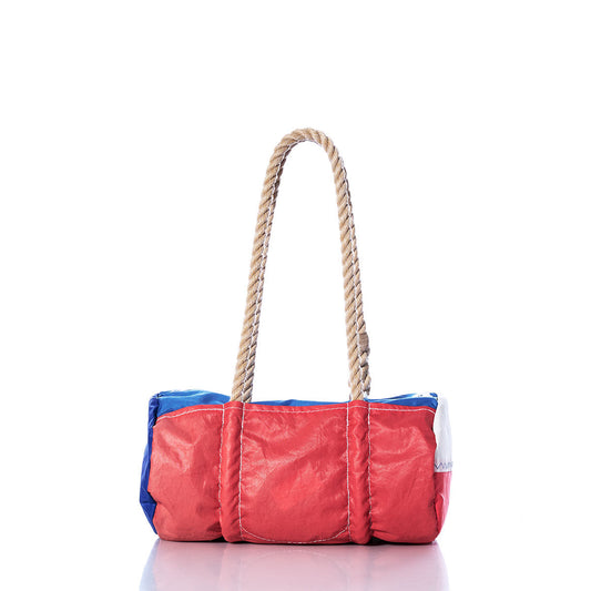 The Sea Bags Vintage Neil Pryde Baguette Bag is a rectangular tote featuring red, blue, and white panels, thick twisted rope handles, and recycled sail bag craftsmanship, shown photographed on a white background. by Sea Bags