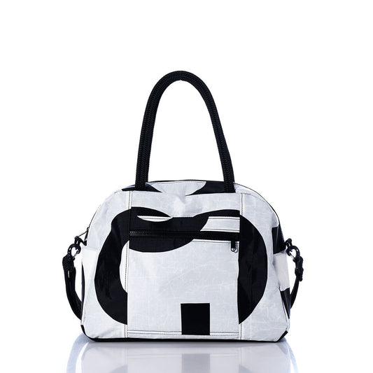 The Sea Bags Vintage Black and White Essential Weekender Travel Bag, featuring striking black abstract patterns on a white background, black handles, a front zip pocket, and side clips—ideal as an Essential Weekender Travel Bag or convenient carryon—is displayed on a reflective surface against a white backdrop. by Sea Bags