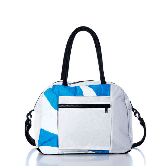 Sea Bags Vintage Blue and White Essential Weekender Travel Bag features white body panels with striking black handles and blue abstract pattern accents, a front zippered pocket, and a detachable shoulder strap—making it the perfect chic carry-on or overnight bag. Shown displayed on a reflective white surface. by Sea Bags