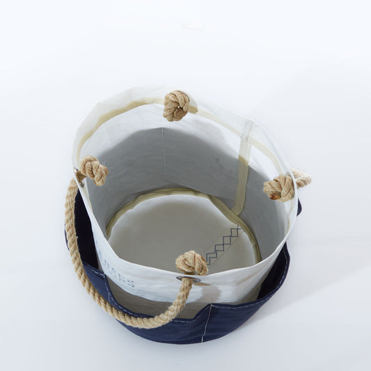 The All Purpose Navy Tool Bucket Bag by Sea Bags is an open-top canvas bucket bag with rope handles and knotted ends, shown from above on a white background—an ideal and stylish way to organize your gardening tools. by Sea Bags