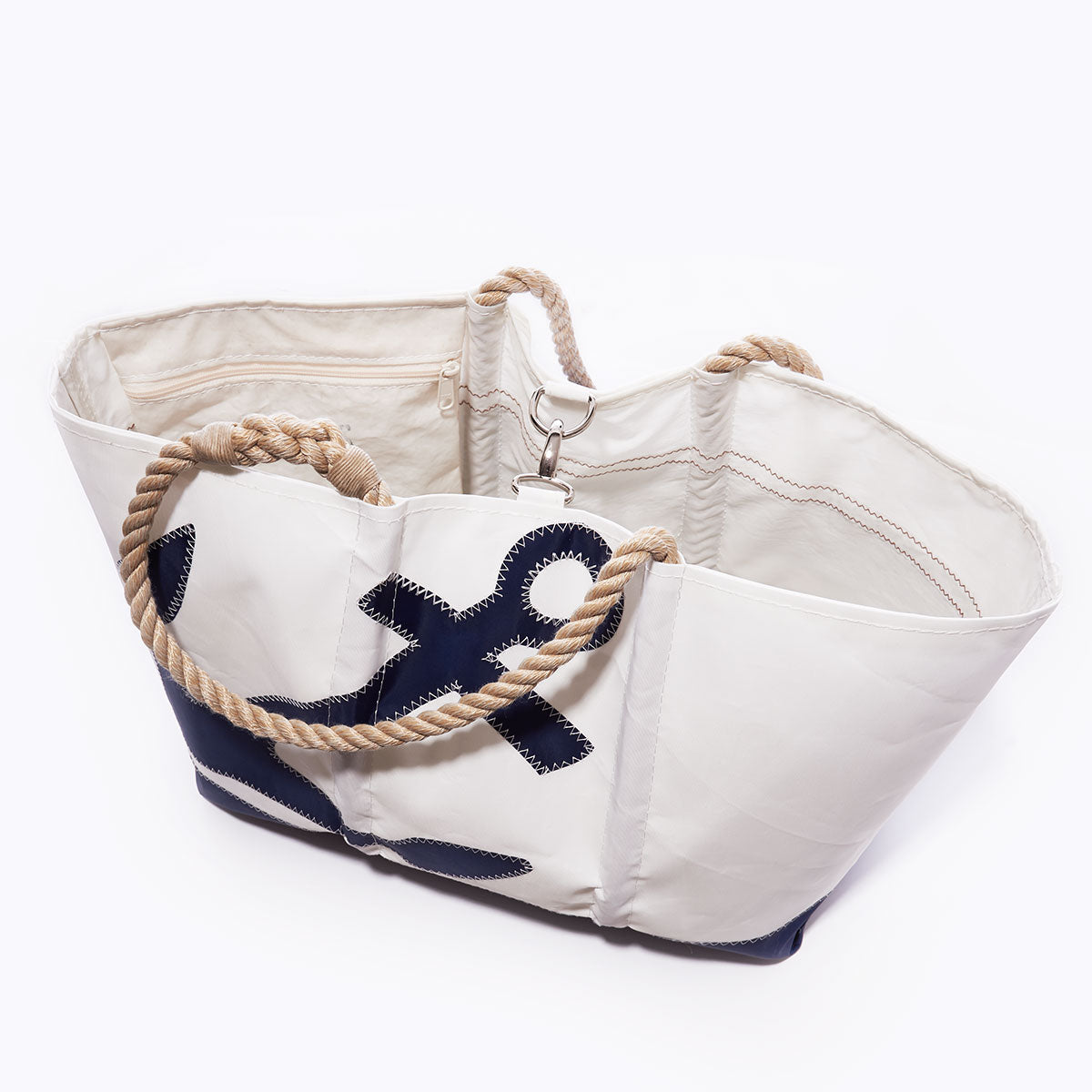 The Sea Bags Navy Anchor Ogunquit Beach Tote, crafted from recycled sail cloth and featuring sturdy rope handles with a bold navy blue anchor design on the side, is displayed against a plain white background. by Sea Bags