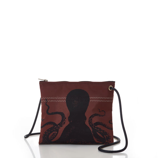 The Sea Bags Tanbark Octopus Slim Crossbody Bag is a small maroon accessory featuring a black octopus silhouette, designed in a nautical style with a zipper closure and thin shoulder strap. Displayed on a white background, this bag is part of the tanbark bags collection and makes an ideal choice for ocean-inspired fashion enthusiasts. by Sea Bags