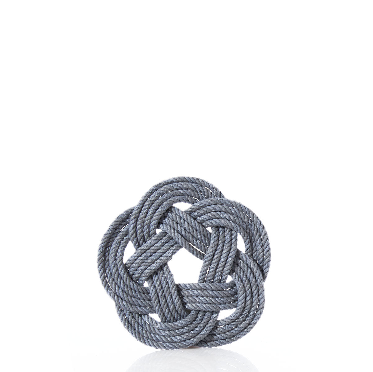 A gray rope is intricately woven into a circular Turk’s head knot, forming the Nautical Sailor Knot Coaster – Grey by Mystic Knotwork, displayed against a plain white background. by Sea Bags