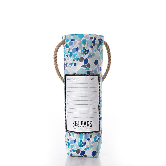 A cylindrical wine bag handcrafted from recycled sail cloth, the Sea Bags Sea Glass Print Wine Bag features blue and teal patterns inspired by sea glass, sturdy rope handles, and a front label that reads Sea Bags Maine. by Sea Bags