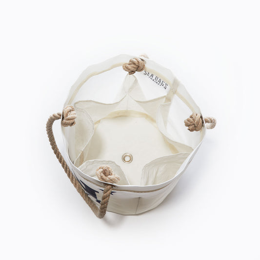 US Naval Academy Beverage Bucket by Sea Bags, crafted from recycled sail cloth with rope handles and a metal grommet at the bottom, seen from above on a plain white background. by Sea Bags