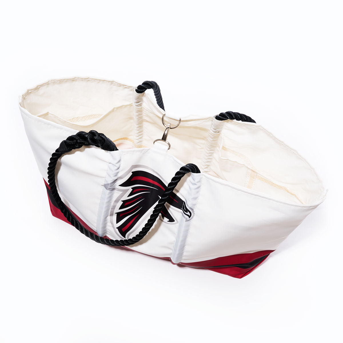Atlanta Falcons Tailgate Tote by Sea Bags, featuring a white and red design with black rope handles and a stylized bird head logo on the front, photographed on a white background. Crafted from recycled sail cloth, this tote combines eco-friendly materials with bold team spirit. by Sea Bags