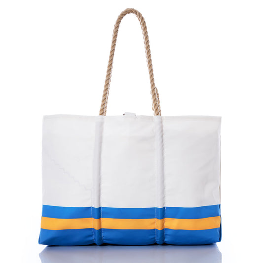 The Los Angeles Chargers Tailgate Tote by Sea Bags is a white tote bag with rope handles, accented by blue and yellow horizontal stripes near the bottom. Made from recycled sail cloth and shown on a white background, it’s perfect for fans who want to showcase their Chargers pride. by Sea Bags