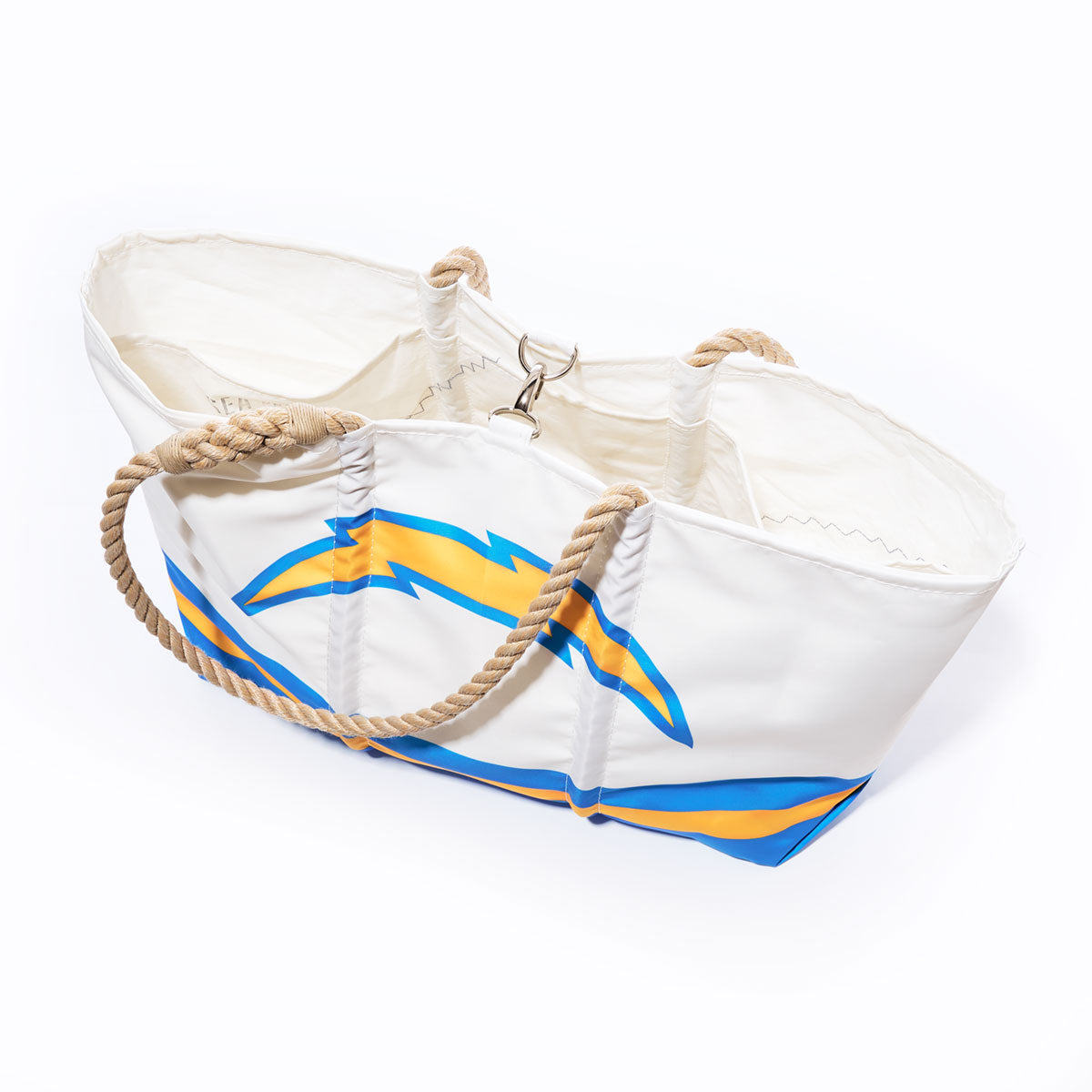 Carry your essentials in style with the Los Angeles Chargers Tailgate Tote from Sea Bags—a white canvas bag showcasing a bold yellow and blue lightning bolt design. Featuring thick twisted rope handles and a secure metal clasp inside, this versatile tote combines sturdy construction with team spirit, making it perfect for everyday use or cheering on your favorite team. by Sea Bags