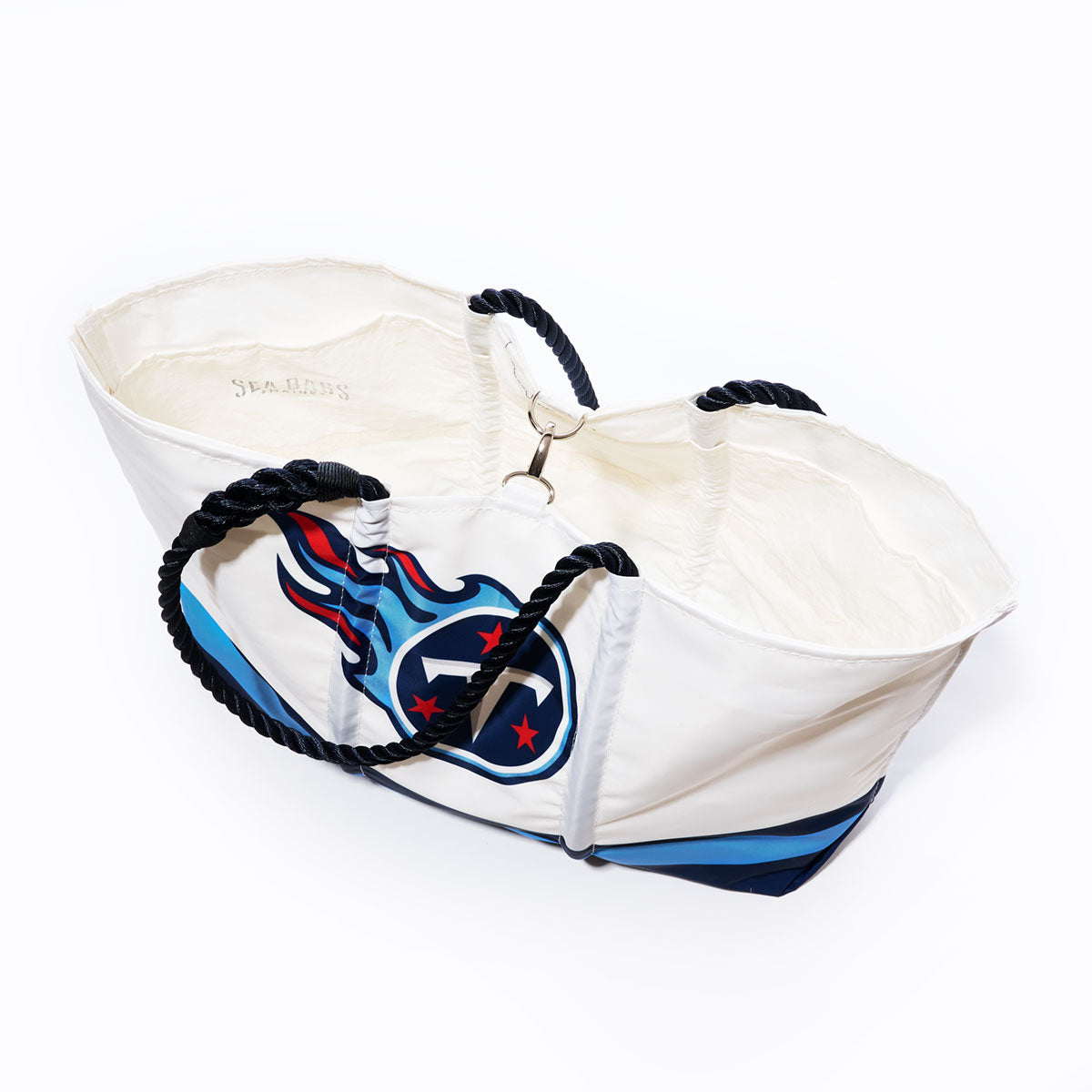 Introducing the Tennessee Titans Tailgate Tote by Sea Bags—a large white tote bag crafted from durable recycled sail cloth for style and sustainability. Featuring navy blue rope handles, the official Tennessee Titans logo, and a spacious off-white interior, this NFL logo bag is perfect for any Titans fan. Displayed against a plain white background. by Sea Bags