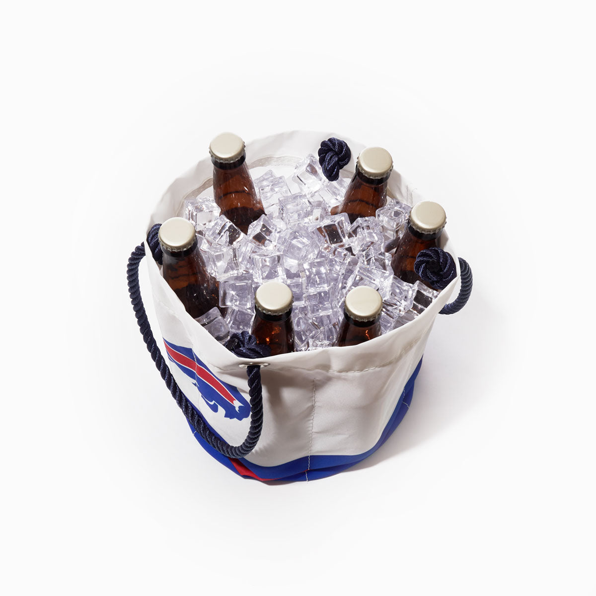 Six brown glass bottles are chilled in ice cubes inside a white Sea Bags Buffalo Bills Beverage Bucket featuring rope handles and a blue and red Buffalo Bills logo. by Sea Bags