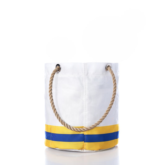 The Los Angeles Rams Beverage Bucket by Sea Bags features white canvas with tan rope handles, yellow and blue horizontal stripes near the base, and metal grommets at the top—combining nautical elegance with team spirit, this stylish and sustainable cooler is perfect for carrying everyday essentials or enjoying weekend adventures. by Sea Bags