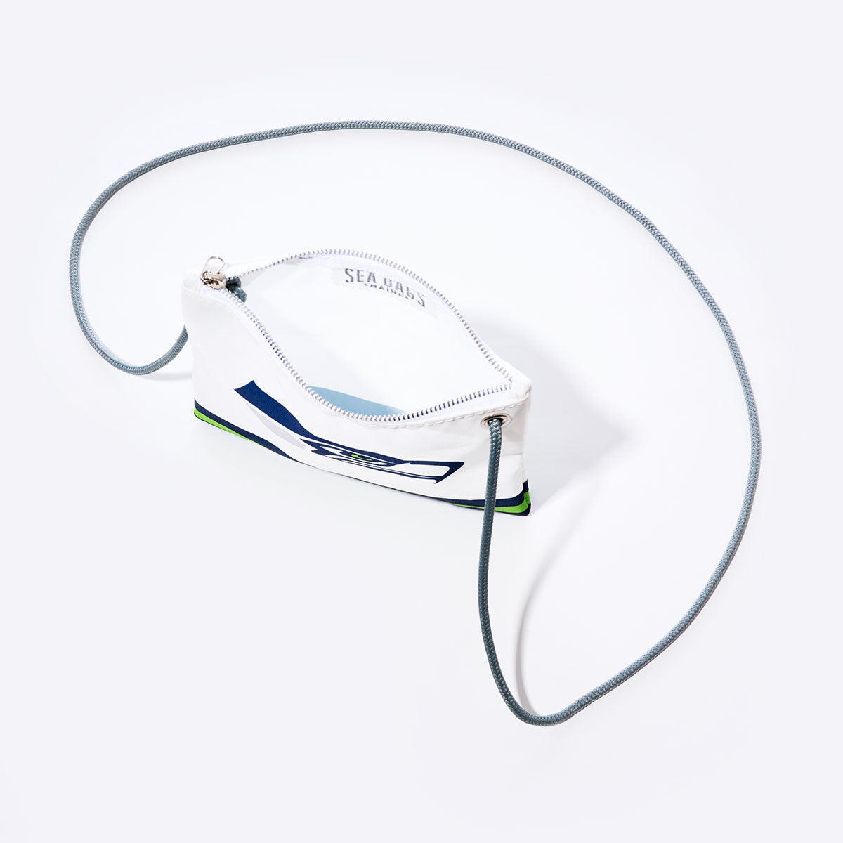 The Sea Bags Seattle Seahawks Slim Crossbody is a small white zippered pouch crafted from recycled sail cloth, featuring a navy and green abstract design reminiscent of a Seahawks bag. It includes a silver zipper and a thin gray cord strap, shown against a white background. by Sea Bags