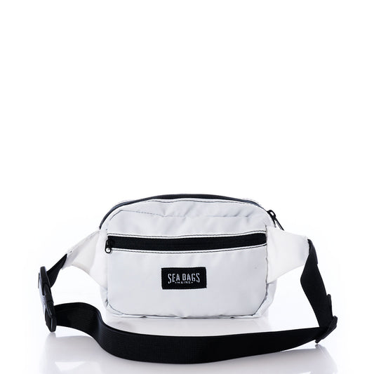 Miami Dolphins Belt Bag by Sea Bags, crafted from recycled sail cloth and designed with black zippers and a black adjustable strap. The sustainable white belt bag features a front pocket adorned with the Sea Bags logo patch, shown against a white background. by Sea Bags