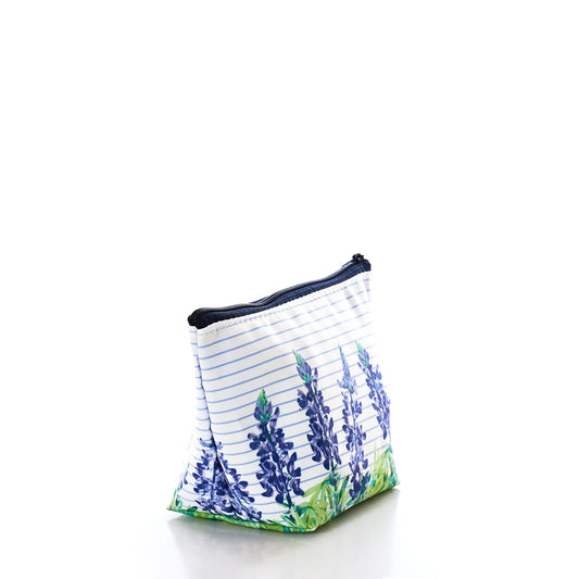 The Lupine Sailor Stripe Cosmetic Bag by Sea Bags features blue and green floral prints accented with horizontal blue stripes. Crafted from durable, washable sailcloth, this small zippered makeup bag sits atop a white surface against a white background, radiating effortless coastal charm. by Sea Bags