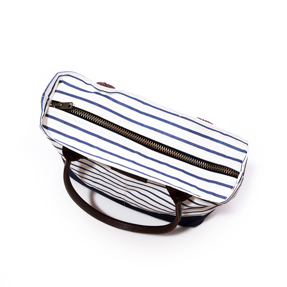 The Navy Mariner Stripe Chebeague Handbag by Sea Bags, handmade from recycled sail cloth with brown handles and a zippered closure, features white and navy stripes and is photographed from above against a white background—an artisanal tote inspired by the coastal charm of Chebeague Island. by Sea Bags