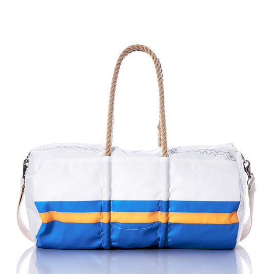 Crafted from recycled sail cloth, the Los Angeles Chargers Duffel by Sea Bags features blue and yellow stripes, rope handles, and a detachable shoulder strap. Displayed on a reflective surface against a white background, this stylish NFL bag is perfect for Chargers fans who value both sustainability and team pride. by Sea Bags