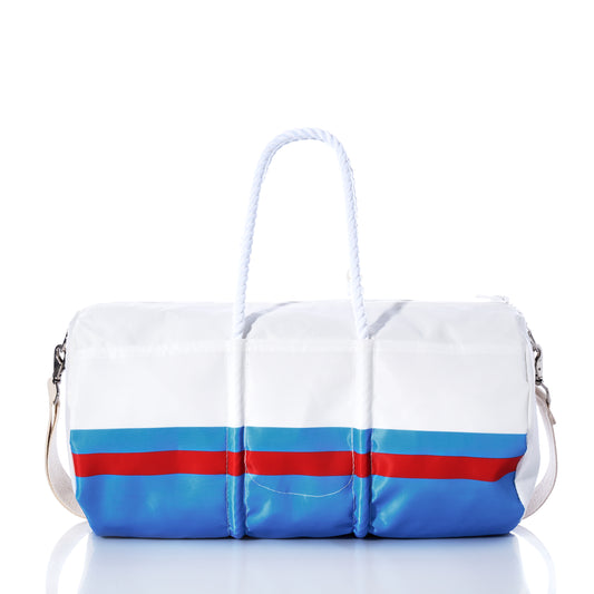 The Tennessee Titans Duffel by Sea Bags is crafted from recycled sail cloth in white and navy blue, featuring a light blue stripe, navy rope handles, and a shoulder strap. The bag is displayed on a reflective surface against a white background. by Sea Bags