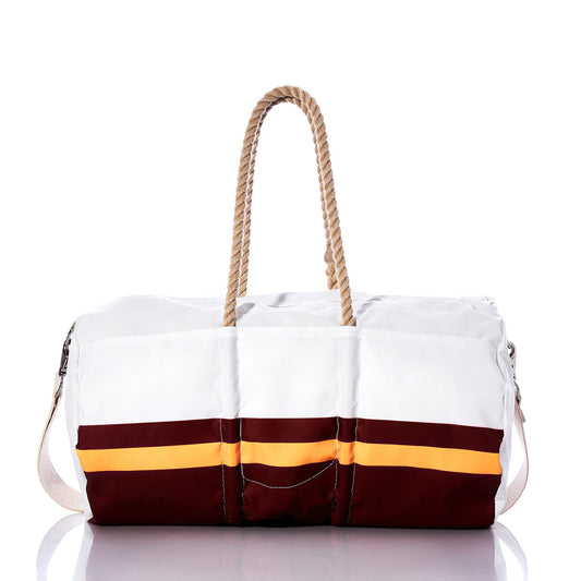 The Sea Bags Washington Commanders Duffel, crafted from recycled sail cloth, showcases white and maroon panels with an orange stripe, complemented by rope handles and a cream-colored shoulder strap. It is displayed on a reflective surface. by Sea Bags