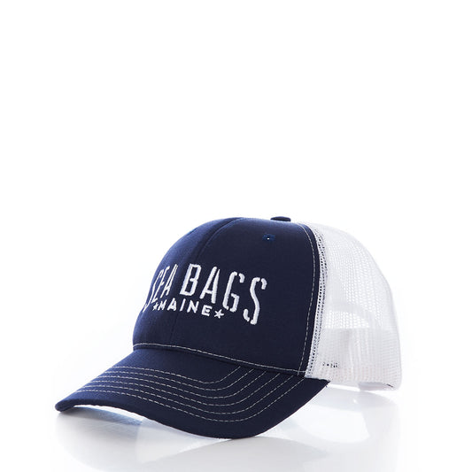 The Sea Bags Trucker Hat by 320Ink d/b/a Riptide Print Company is shown on a white background, featuring a navy blue and white design with SEA BAGS MAINE text on the front, white stitching, and a mesh back panel for enhanced sun protection. This adjustable trucker cap combines comfort and style. by Sea Bags
