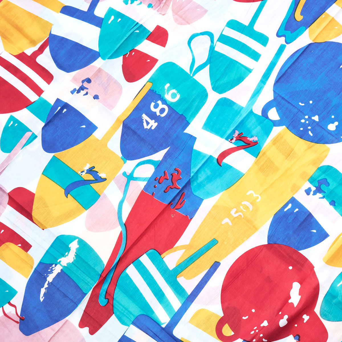 Introducing the Downeast Buoys Scarf by Batela USA Inc—a vibrant cotton accessory adorned with colorful abstract shapes, overlapping sailboat sails, paddles, and numbers in shades of red, blue, yellow, and teal on a crisp white background. This lively scarf is the perfect nautical addition to any wardrobe. by Sea Bags