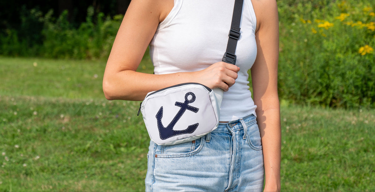 belt or sling bag, aka waist or fanny pack, worn by woman in a crossbody fashion, with anchor design