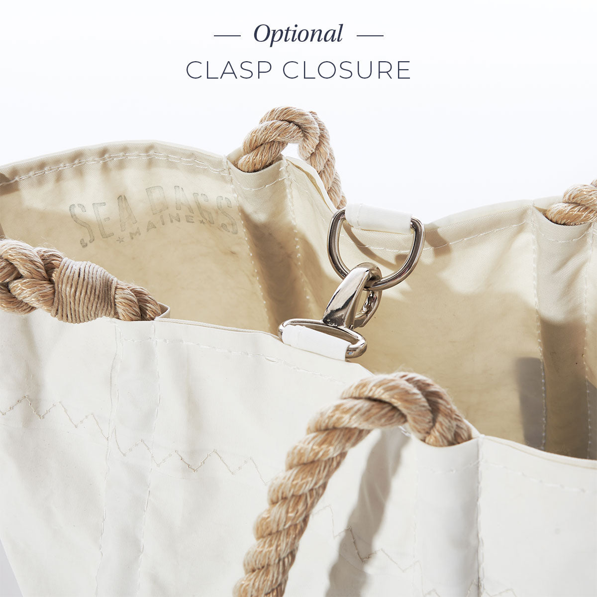 Close-up of the Sea Bags Custom Date Tote featuring tan rope handles and a partially fastened metal clasp closure. Text above reads Optional Clasp Closure. by Sea Bags