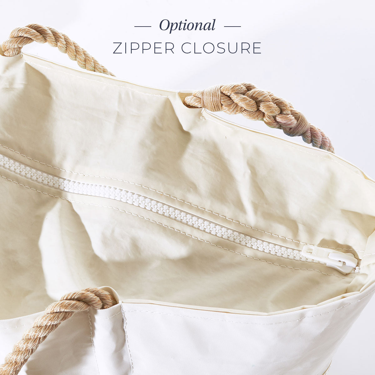 Sea Bags Custom Date Tote is a white canvas tote bag featuring tan rope handles and an optional white zipper closure, photographed from above on a white background. Adorned with a custom message patch, this tote is perfect for showcasing your unique style. by Sea Bags