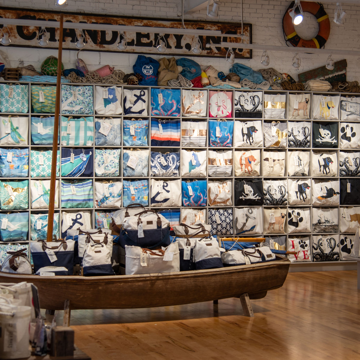 A huge retail display of tote designs featuring sea creatures, watercolor, dogs, and nautical themes
