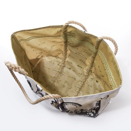 Sea Bags Octopus Large Tote with Clasp features beige and white coloring, sturdy rope handles, and opens to reveal a light yellow interior adorned with a cursive writing pattern. Reminiscent of an oceanography bag, this totes exterior boasts a decorative design and is pictured empty. by Sea Bags