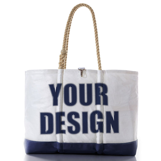 The Sea Bags Custom Design Ogunquit Beach Tote is a white and navy beach bag with rope handles, featuring YOUR DESIGN printed in large, bold blue letters on the front—an ideal personalized accessory crafted for both style and convenience. by Sea Bags