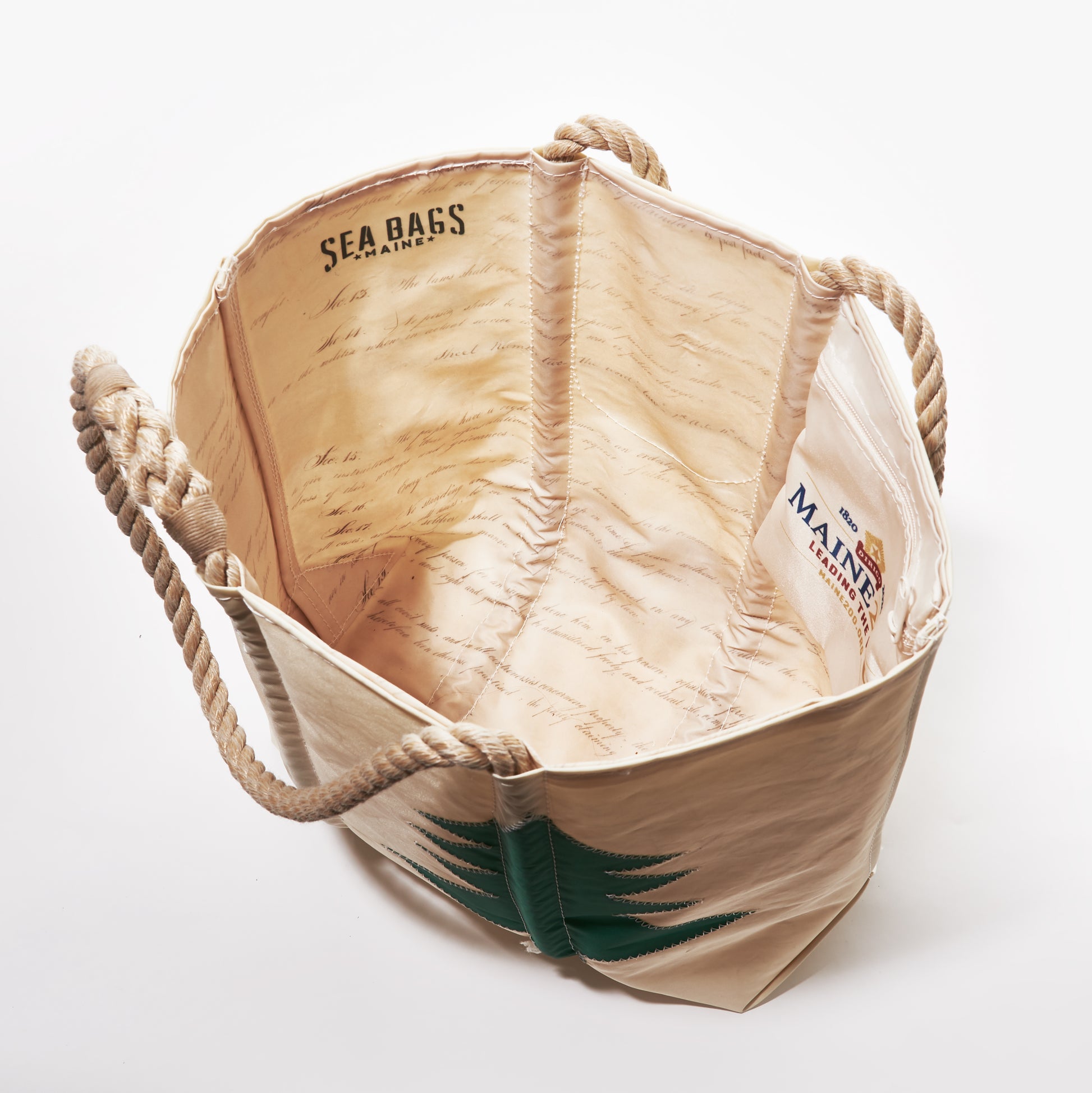 The Sea Bags Maine Bicentennial Medium Tote is a beige bag with rope handles, crafted from recycled sail cloth and featuring an interior print with handwritten-style text and both the Sea Bags and Maine logos—making it a perfect gift from Maine. by Sea Bags