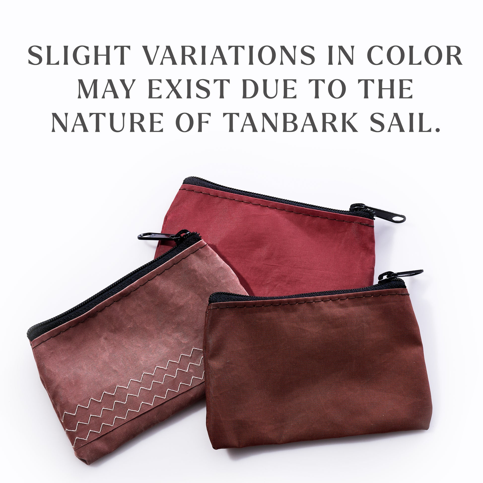 Three Sea Bags Tanbark Everyday Carry Mini Pouches are displayed in an array of reddish-brown hues, each one crafted from recycled tanbark sail for a distinctive link to maritime heritage. The text above notes that slight color variations may occur due to the nature of the repurposed material. by Sea Bags