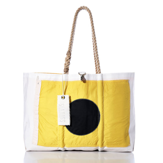 The India Signal Flag Large Tote by Sea Bags is a spacious white bag crafted from recycled sail cloth, featuring a distinctive yellow and black square design inspired by vintage signal flags, rope handles, and a white SENREVE tag, shown on a reflective surface. by Sea Bags