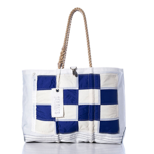 November Signal Flag Large Tote by Sea Bags, featuring navy blue and white checkered panels inspired by vintage signal flags, rope handles, a white Sea Bags tag, and crafted from recycled sail cloth—shown on a white background. by Sea Bags